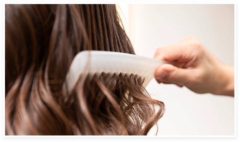 persona peinándole el cabello a una mujer