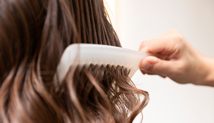 persona peinándole el cabello a una mujer